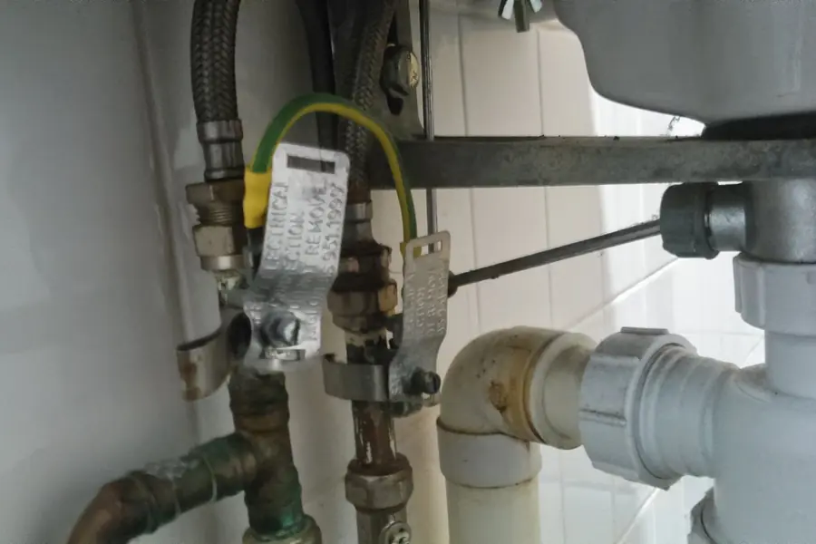 Cañerías y conexiones bajo un lavaplatos, trabajo de gasfitería en Talca