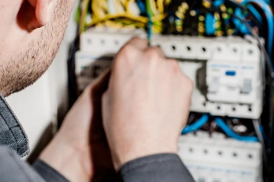 Técnico revisando un tablero eléctrico, reparación de aire acondicionado en Talca